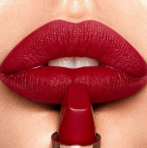 Zoom sur une bouche et un bâton de rouge à lèvres rouge