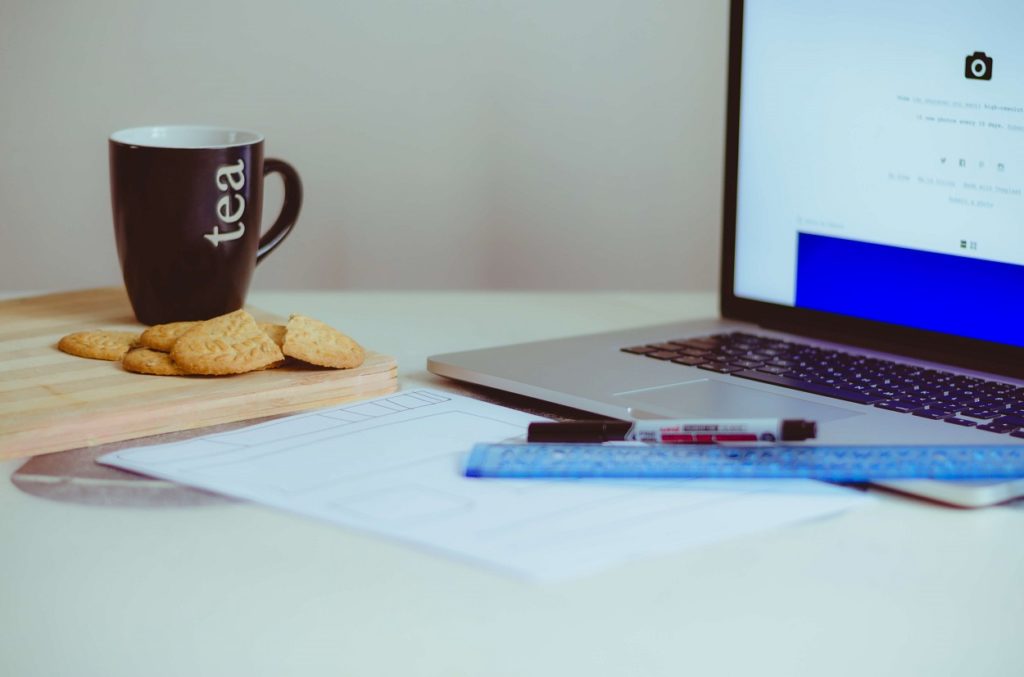 Macbook, tea, ruler, pens and paper on a desk - Healthy Habits - Laura Blog