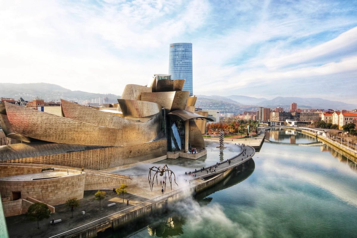 A view of the Guggenheim Museum in Bilbao, Spain, with the canal beside it.