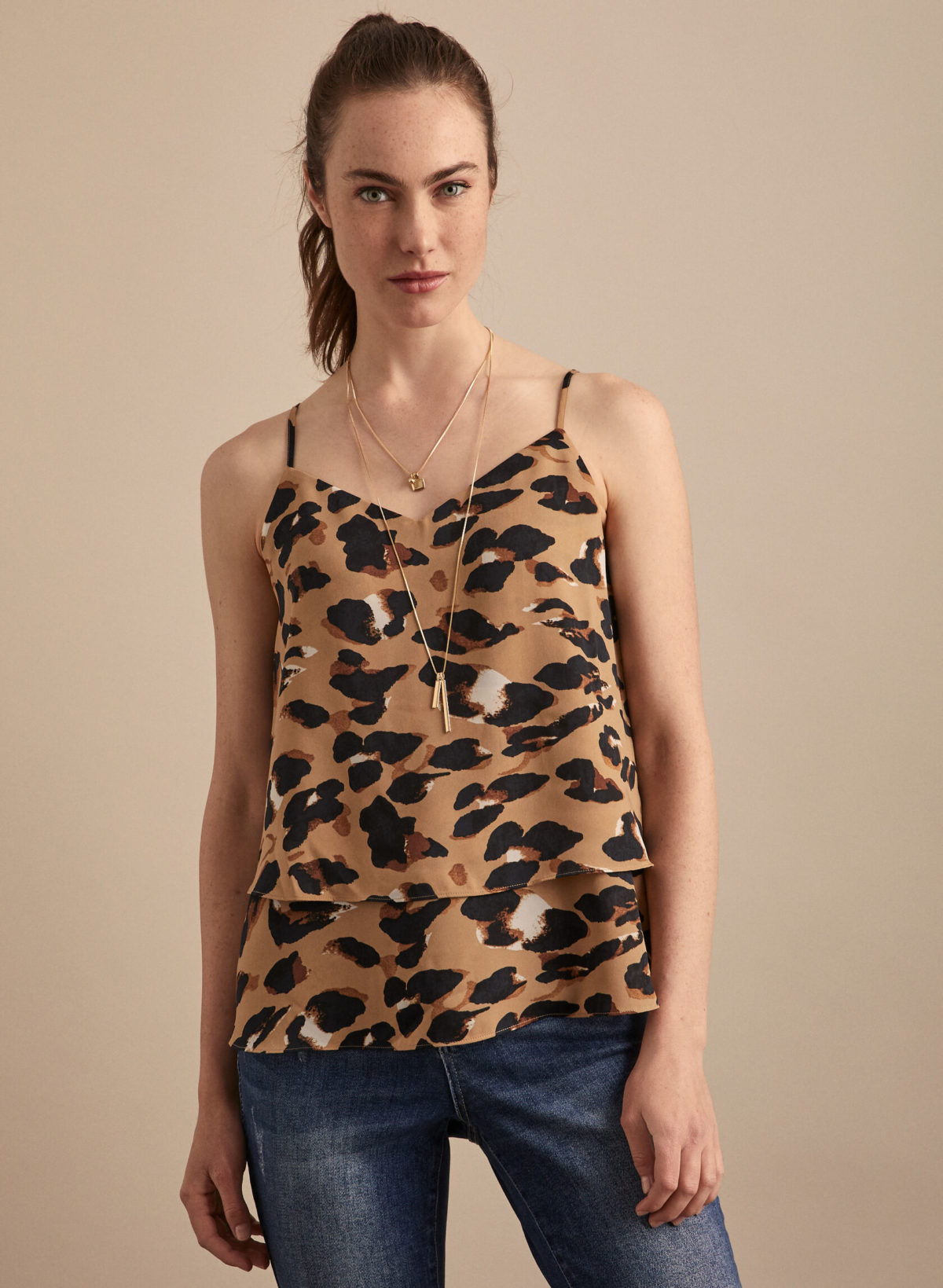 A woman wearing a leopard print camisole.