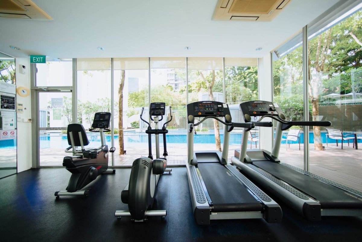 Treadmills and elliptical machines in an apartment gym.