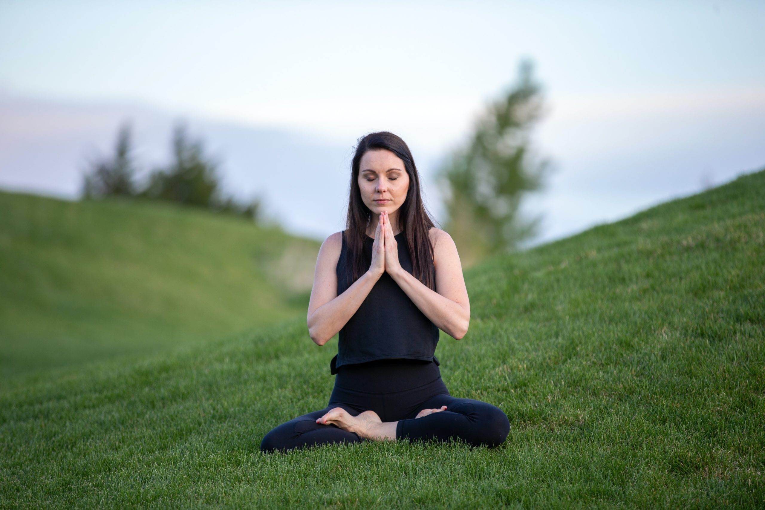 Woman sitting in yoga pose in field