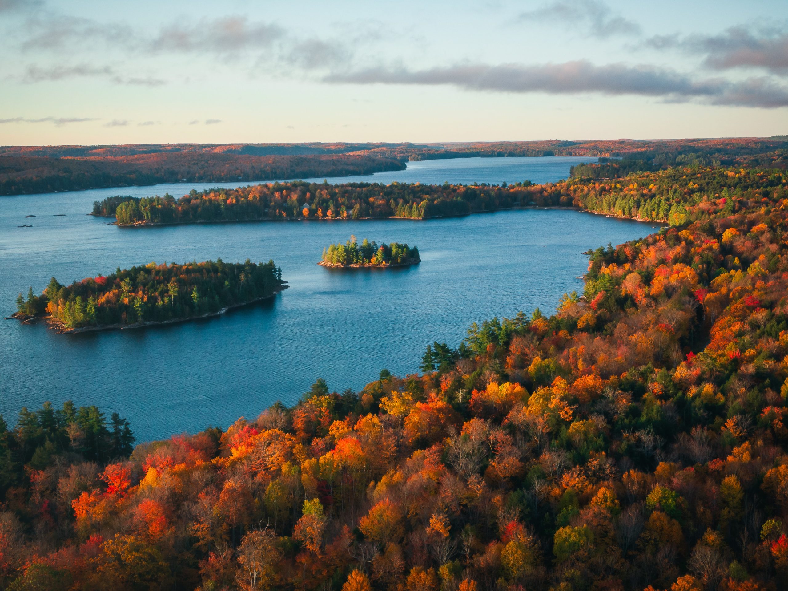 View of fall trees, lake, islands, and sky
