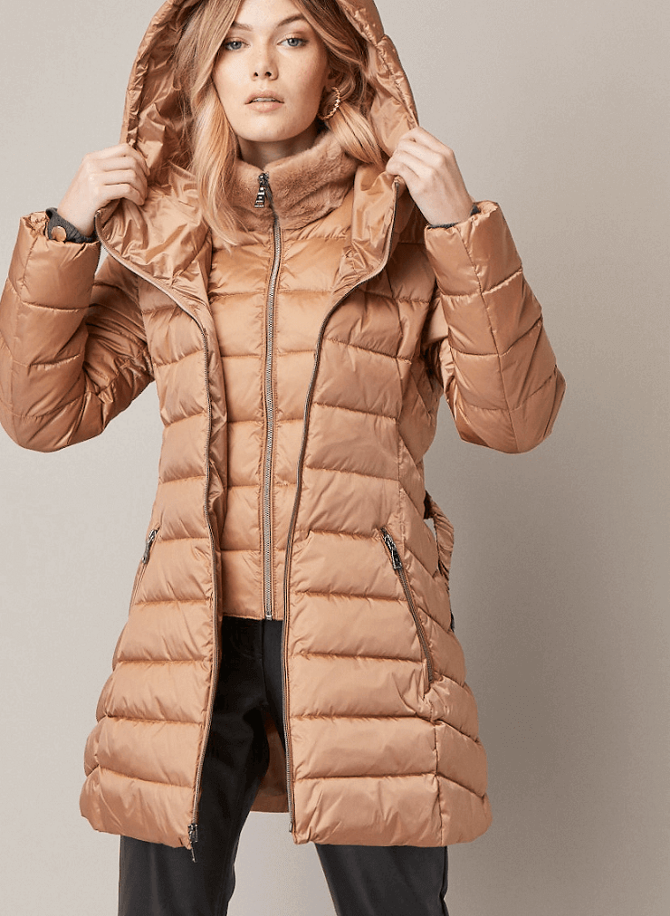 Model wearing quilted coat by Tahari with hood up.