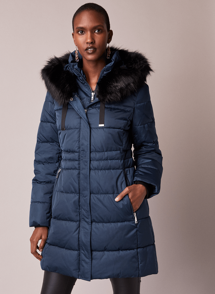 Model is wearing blue quilted coat by Tahari.